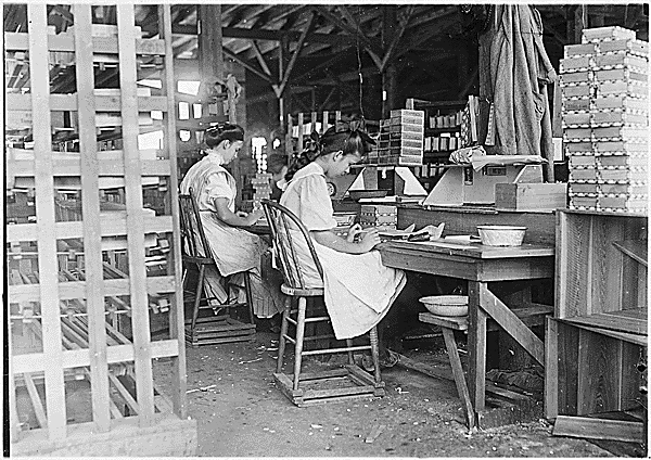 A young girl working alongside a woman in a paper box factory, 1912. From National Archives.