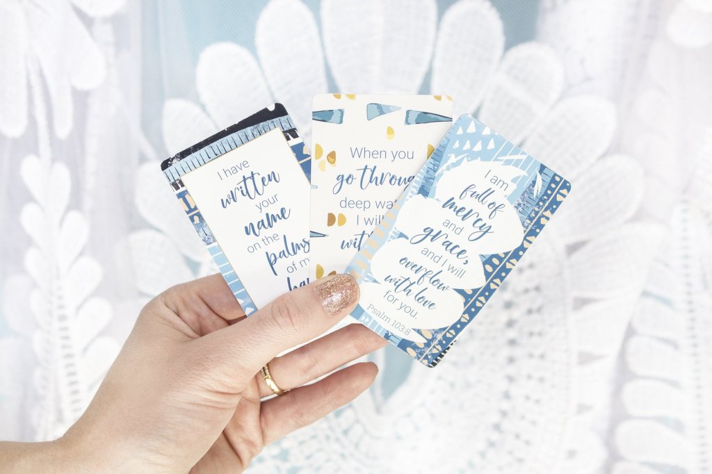 Photo of a woman holding three sample cards, one of which reads "I am full of mercy and grace, and I will overflow with love for you." Psalms 103:8.