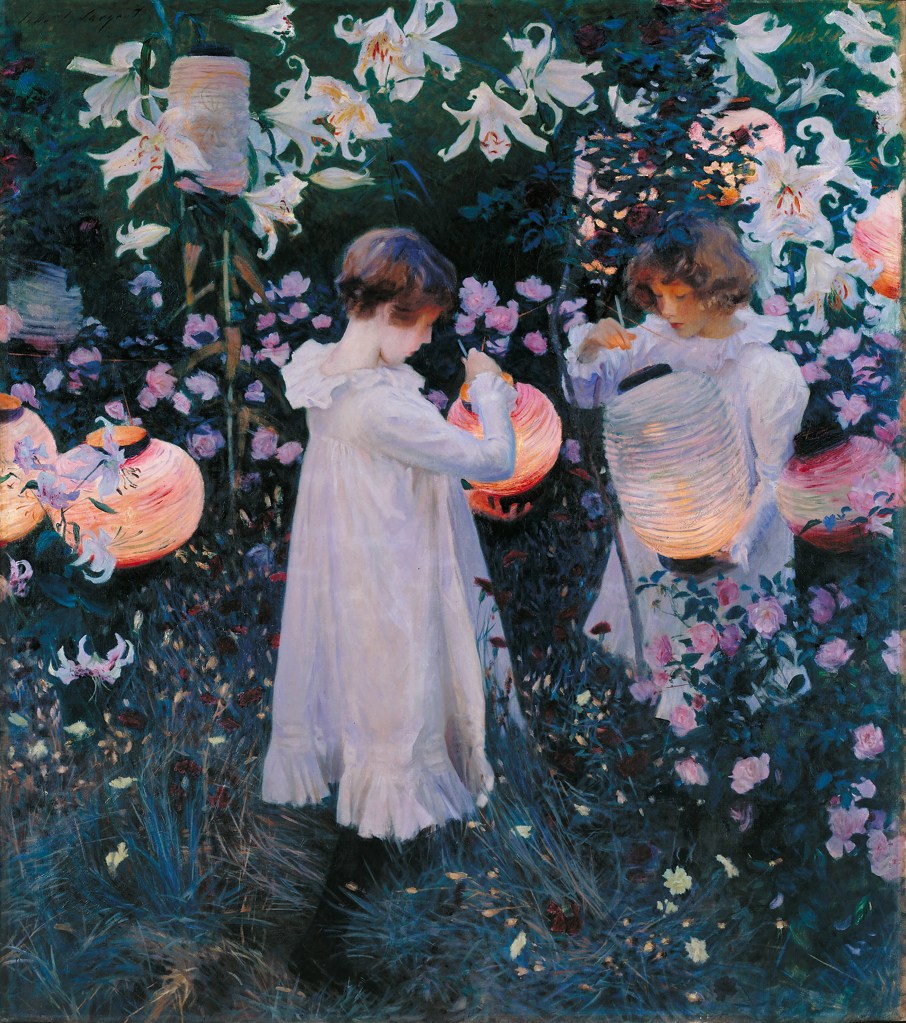 Two young girls stand in a field of grasses, roses, and tall lillies. Each girl holds a paper lantern they are lighting. Around them hang lanterns that are already lit. 