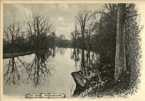 Old black and white photo of the Mohawk River as it winds through a forest of trees.